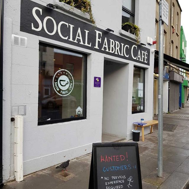 Exterior of Social Fabric Café with a sandwich board